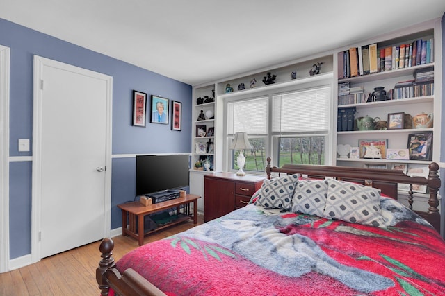 bedroom with light wood-type flooring and baseboards
