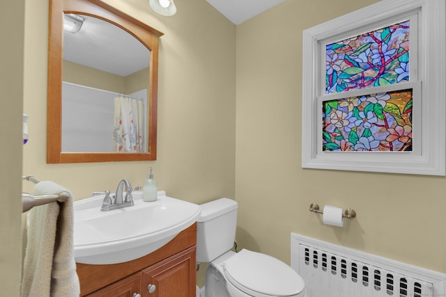 bathroom with toilet, radiator heating unit, and vanity