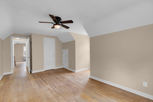 bonus room featuring light wood-style floors, baseboards, a ceiling fan, and vaulted ceiling