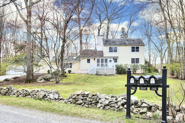 back of property with a lawn and a chimney