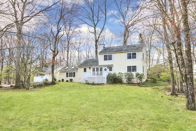 rear view of house featuring a chimney and a lawn