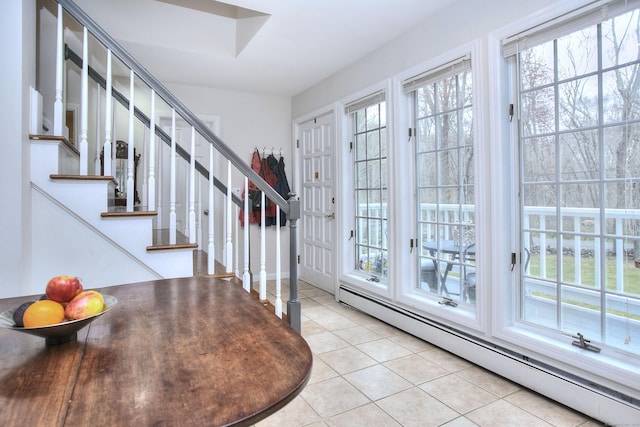 entryway with a baseboard radiator, light tile patterned floors, and stairway