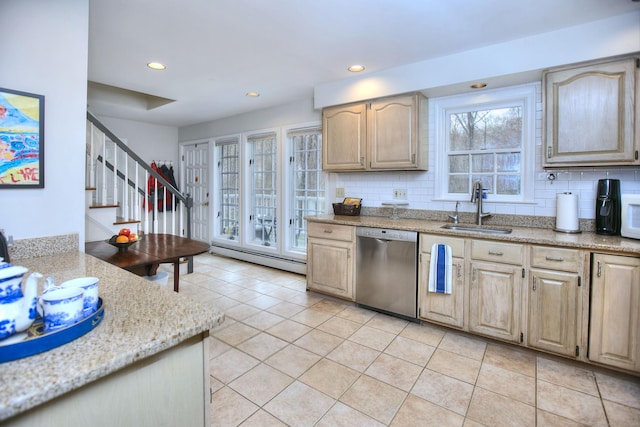 kitchen with a baseboard radiator, decorative backsplash, stainless steel dishwasher, and a sink
