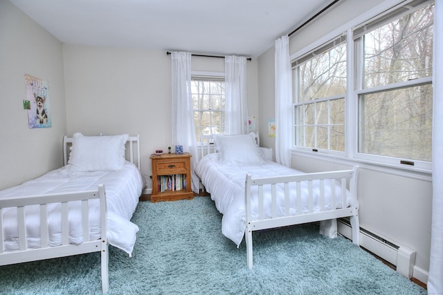 carpeted bedroom featuring a baseboard heating unit and baseboards