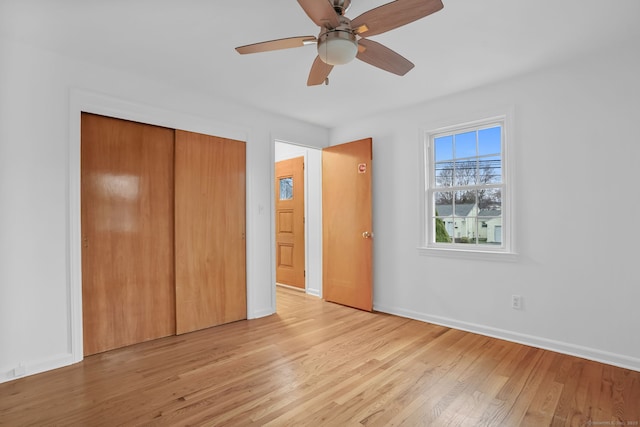 unfurnished bedroom with light wood-style flooring, a closet, baseboards, and ceiling fan