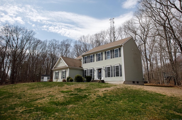 colonial house featuring entry steps and a front lawn