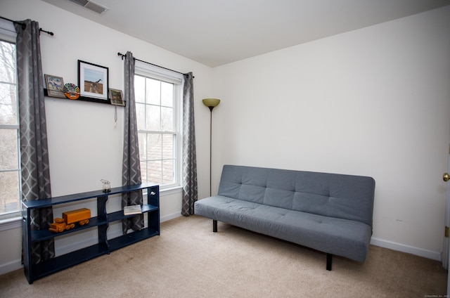 sitting room with carpet, visible vents, a wealth of natural light, and baseboards