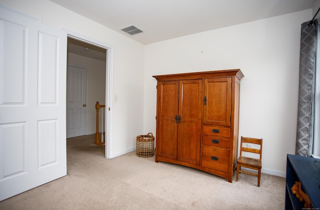 bedroom with baseboards, visible vents, and light colored carpet