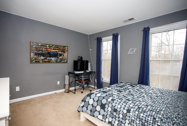 carpeted bedroom with visible vents and baseboards