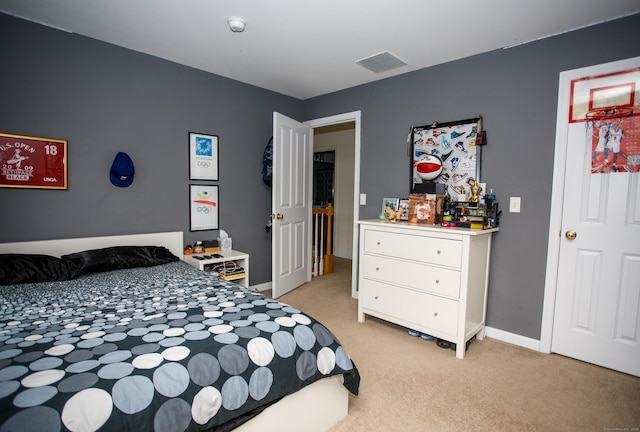 bedroom featuring visible vents, light carpet, and baseboards