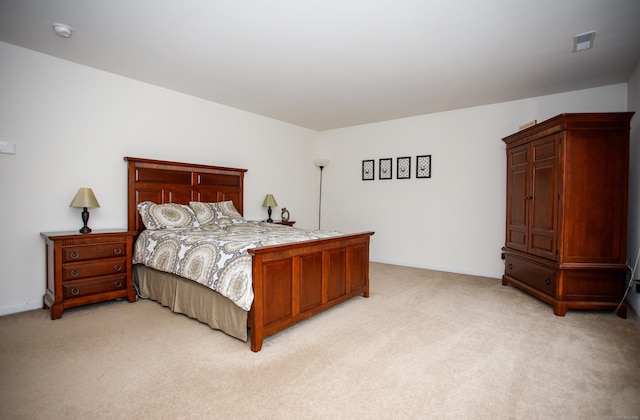 bedroom with visible vents, baseboards, and light carpet