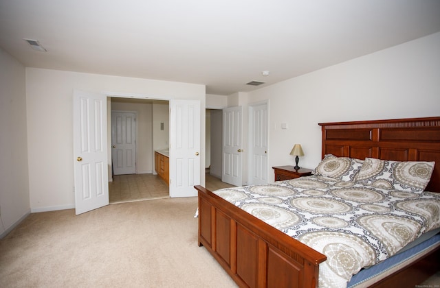 bedroom with baseboards, visible vents, and light colored carpet