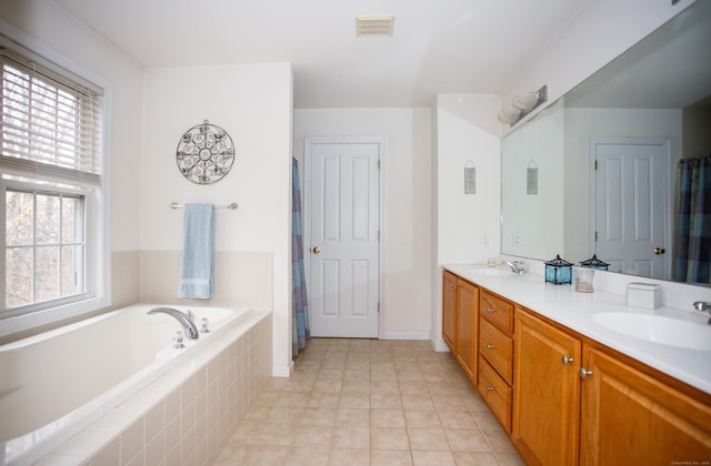 bathroom featuring a garden tub, double vanity, a sink, and visible vents