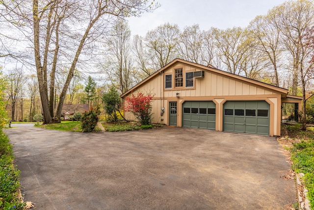 view of side of property featuring an AC wall unit and driveway