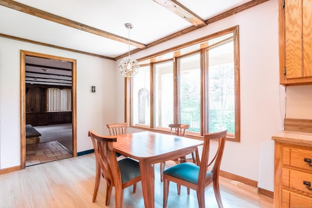 dining room with beamed ceiling, light wood finished floors, and baseboards
