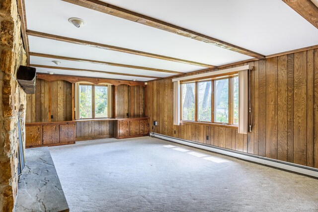 interior space with carpet, wooden walls, and baseboard heating