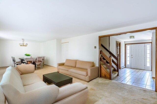 tiled living area with a baseboard heating unit, carpet, and a chandelier