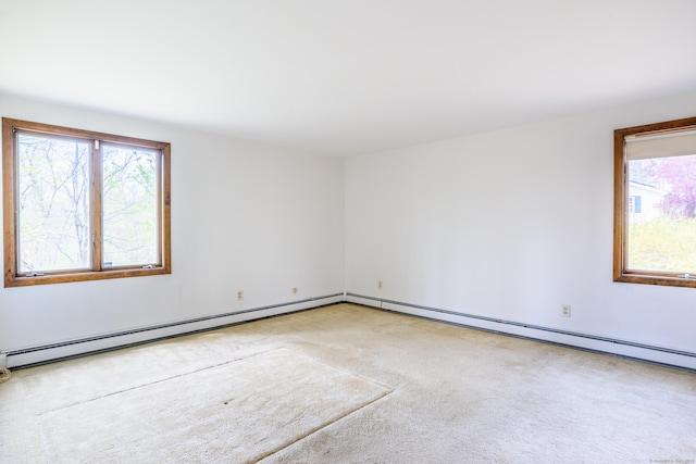 empty room featuring carpet and a baseboard heating unit