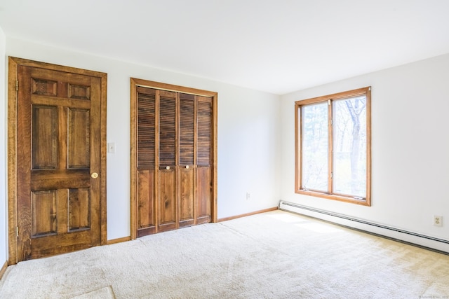 unfurnished bedroom featuring carpet, baseboards, baseboard heating, and a closet