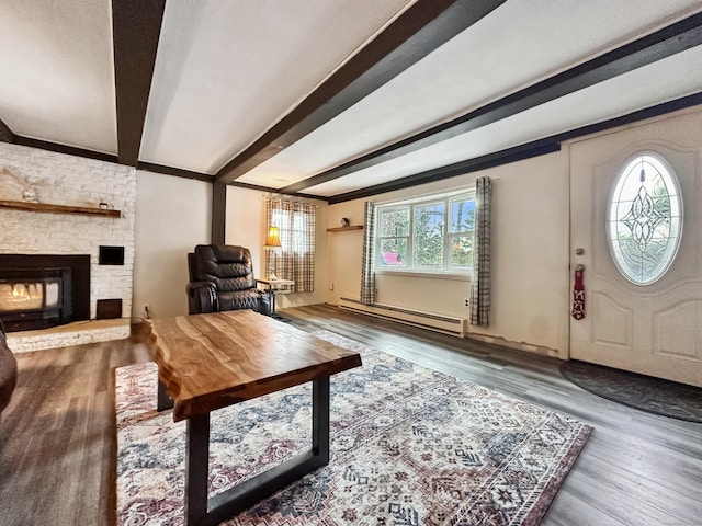 living room featuring a fireplace, beam ceiling, baseboard heating, and wood finished floors