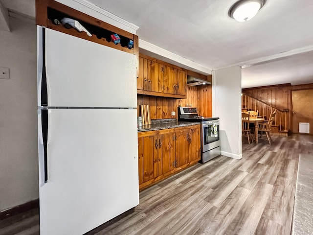 kitchen featuring dark countertops, brown cabinets, stainless steel range with electric stovetop, freestanding refrigerator, and light wood finished floors