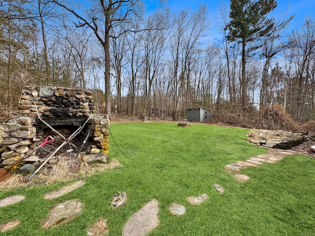 view of yard featuring a storage shed and an outbuilding