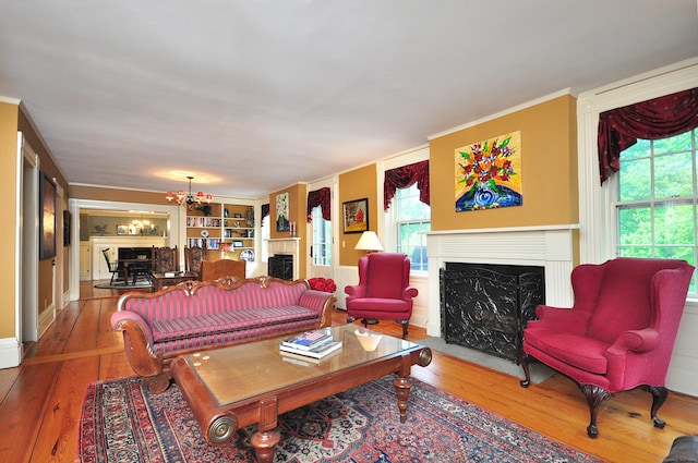 794 Main St, Somers, CT 06071 - living area featuring a fireplace, hardwood / wood-style floors, plenty of natural light, a chandelier, and crown molding