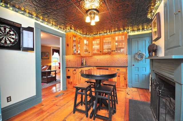 794 Main St, Somers, CT 06071 - dining area featuring light wood finished floors, a fireplace with flush hearth, and an ornate ceiling