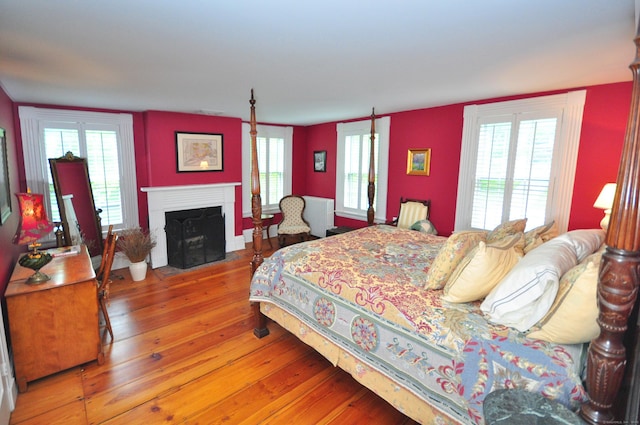 794 Main St, Somers, CT 06071 - bedroom featuring hardwood / wood-style flooring, a fireplace with flush hearth, and multiple windows