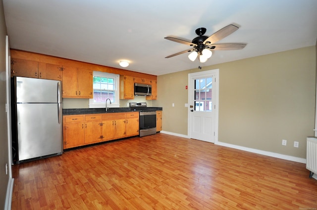 794 Main St, Somers, CT 06071 - kitchen with stainless steel appliances, light wood-type flooring, dark countertops, a ceiling fan, and baseboards