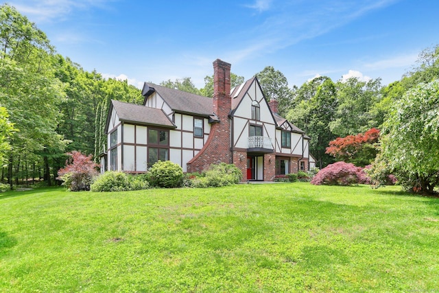 5 Tall Oaks Rd, Wilton, CT 06897 - back of house with a balcony, a lawn, a chimney, and brick siding