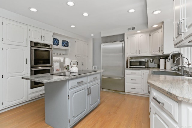 5 Tall Oaks Rd, Wilton, CT 06897 - kitchen with appliances with stainless steel finishes, white cabinetry, a center island, recessed lighting, and light wood-style flooring