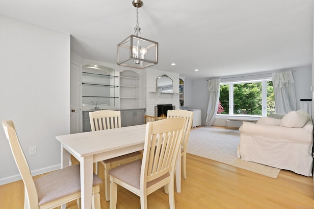 5 Tall Oaks Rd, Wilton, CT 06897 - dining space featuring light wood-style flooring, a brick fireplace, recessed lighting, and a chandelier