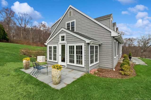 rear view of house featuring a lawn and a patio area