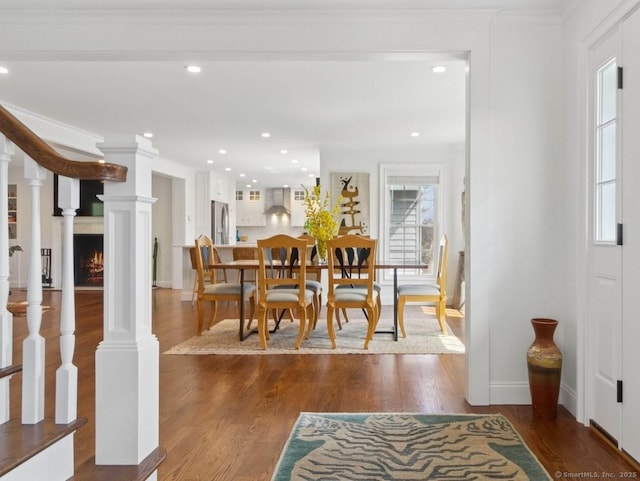 dining room with crown molding, wood finished floors, baseboards, stairway, and recessed lighting