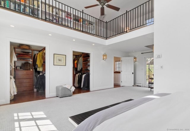 bedroom with a spacious closet, a towering ceiling, a closet, recessed lighting, and carpet
