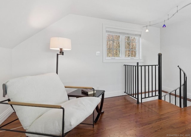 sitting room with an upstairs landing, baseboards, and wood finished floors