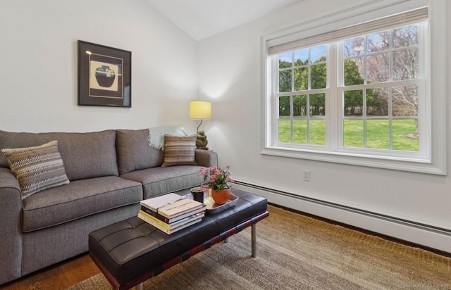living room with baseboard heating, lofted ceiling, and wood finished floors