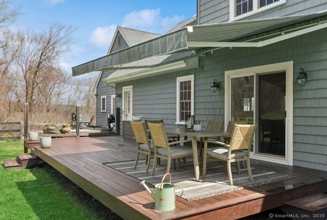 deck with outdoor dining space and fence