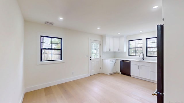 101 Parade Hill Rd, New Canaan, CT 06840 - kitchen featuring baseboards, light wood-style flooring, visible vents, dishwashing machine, and a sink