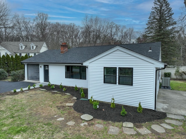 101 Parade Hill Rd, New Canaan, CT 06840 - view of front of home featuring cooling unit, roof with shingles, an attached garage, a chimney, and driveway
