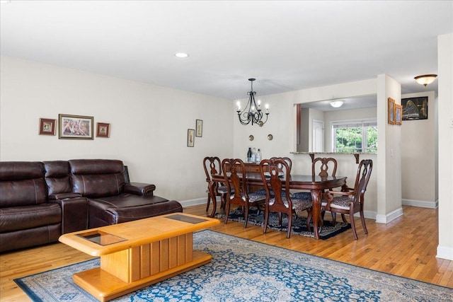 dining room featuring recessed lighting, wood finished floors, baseboards, and a notable chandelier