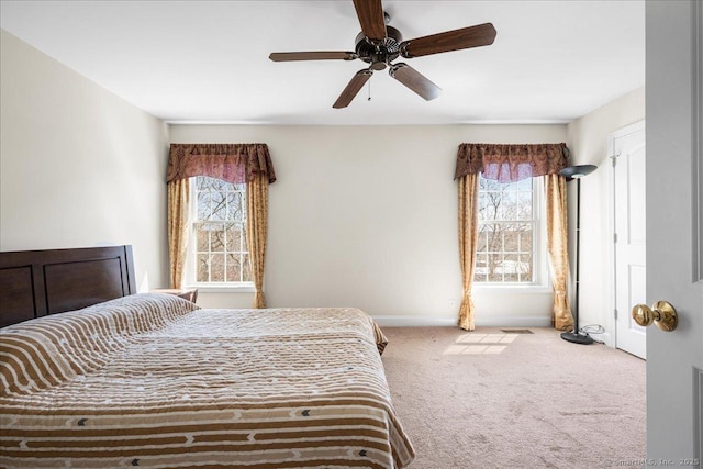 bedroom featuring carpet, a ceiling fan, baseboards, and multiple windows