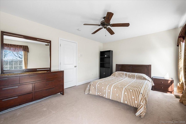 bedroom with light carpet, a ceiling fan, and baseboards