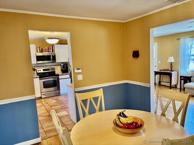 dining area with light tile patterned flooring and ornamental molding