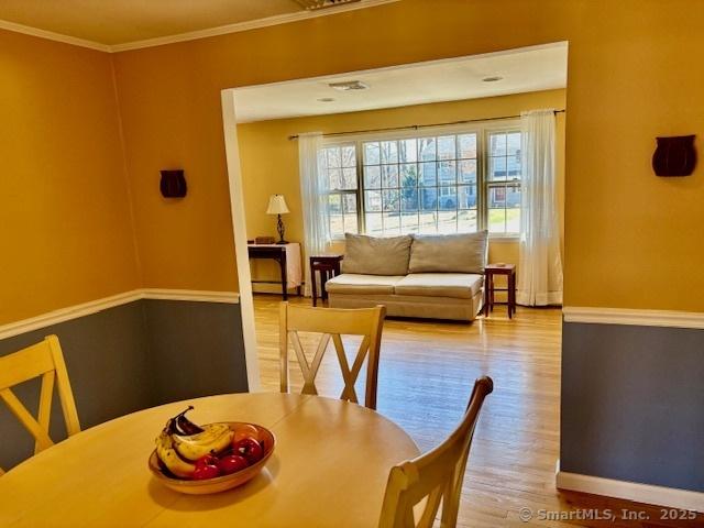 dining area with crown molding, baseboards, and wood finished floors