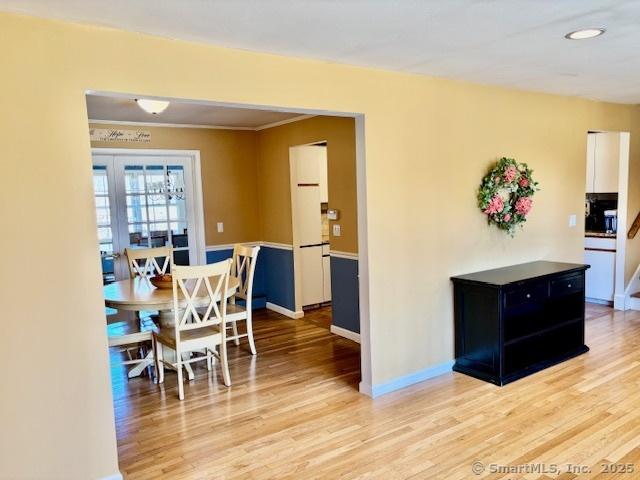 dining area with light wood finished floors and baseboards