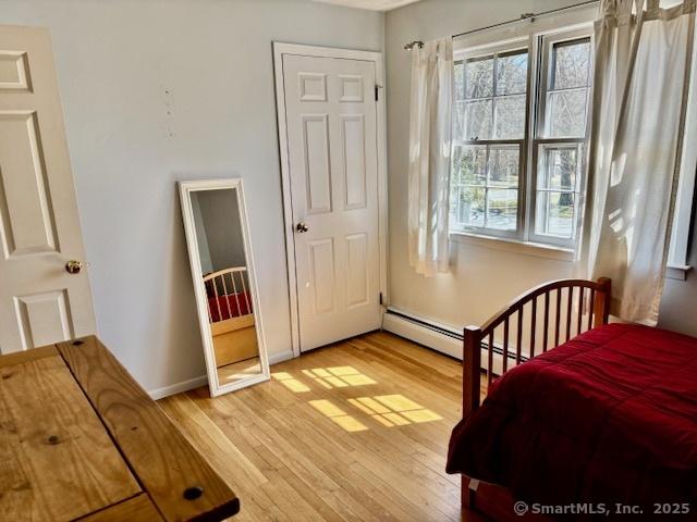 bedroom with light wood-style flooring and baseboards