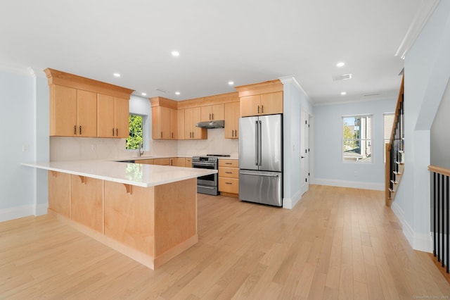 56-58 E Main St, Stonington, CT 06355 - kitchen featuring a peninsula, light countertops, under cabinet range hood, stainless steel appliances, and light brown cabinetry