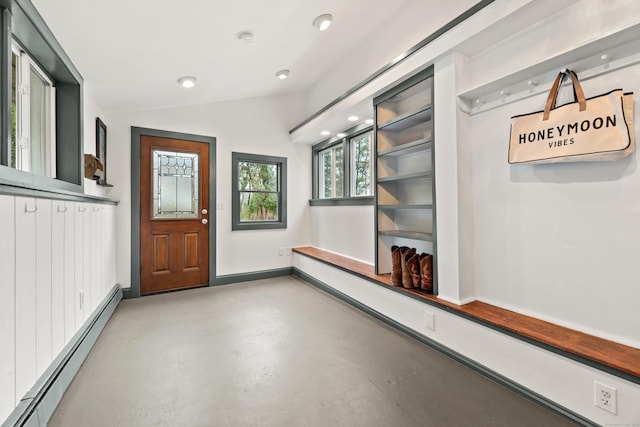 interior space featuring a baseboard radiator, finished concrete floors, vaulted ceiling, and baseboards